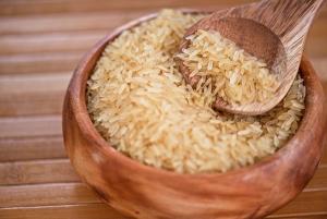 A wooden bowl full of uncooked bran rice.