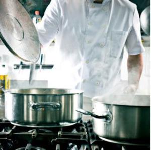An image of a chef opening a stainless steel pot on a cooktop.