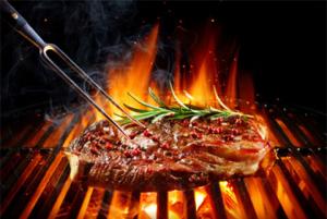 A steak being grilled on a bar-b-que.