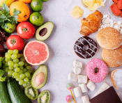 A collection of healthy foods on the left side of the image (e.g. fruits and vegetables) with unhealthy foods on the right side (e.g., donuts, chips, marshmallows)